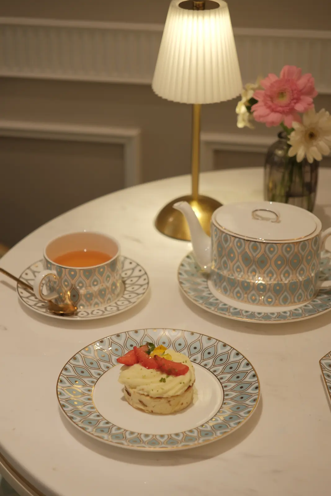 Small cream cake with strawberries beside a cup of tea — Crema Pastry · Classyc Hàng Buồm