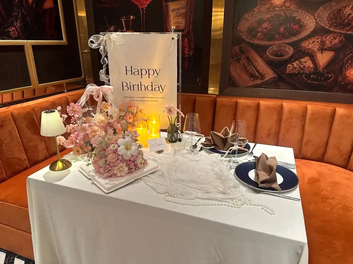 Birthday table with pink flowers, candles and a board — Lumé Restaurant · Classyc Hàng Buồm