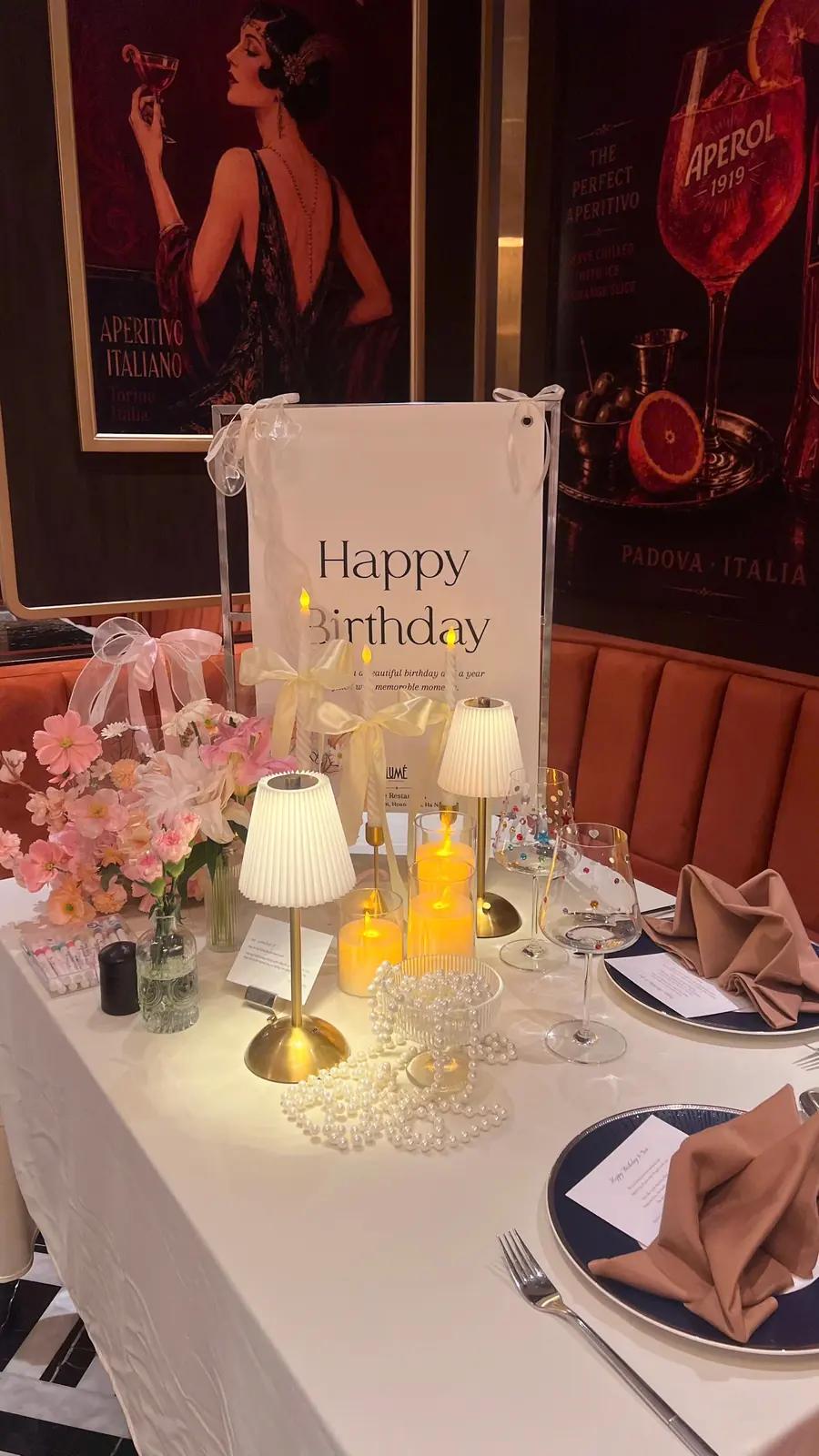 Birthday table with candles and a poster of a drawn woman — Lumé Restaurant · Classyc Hàng Buồm
