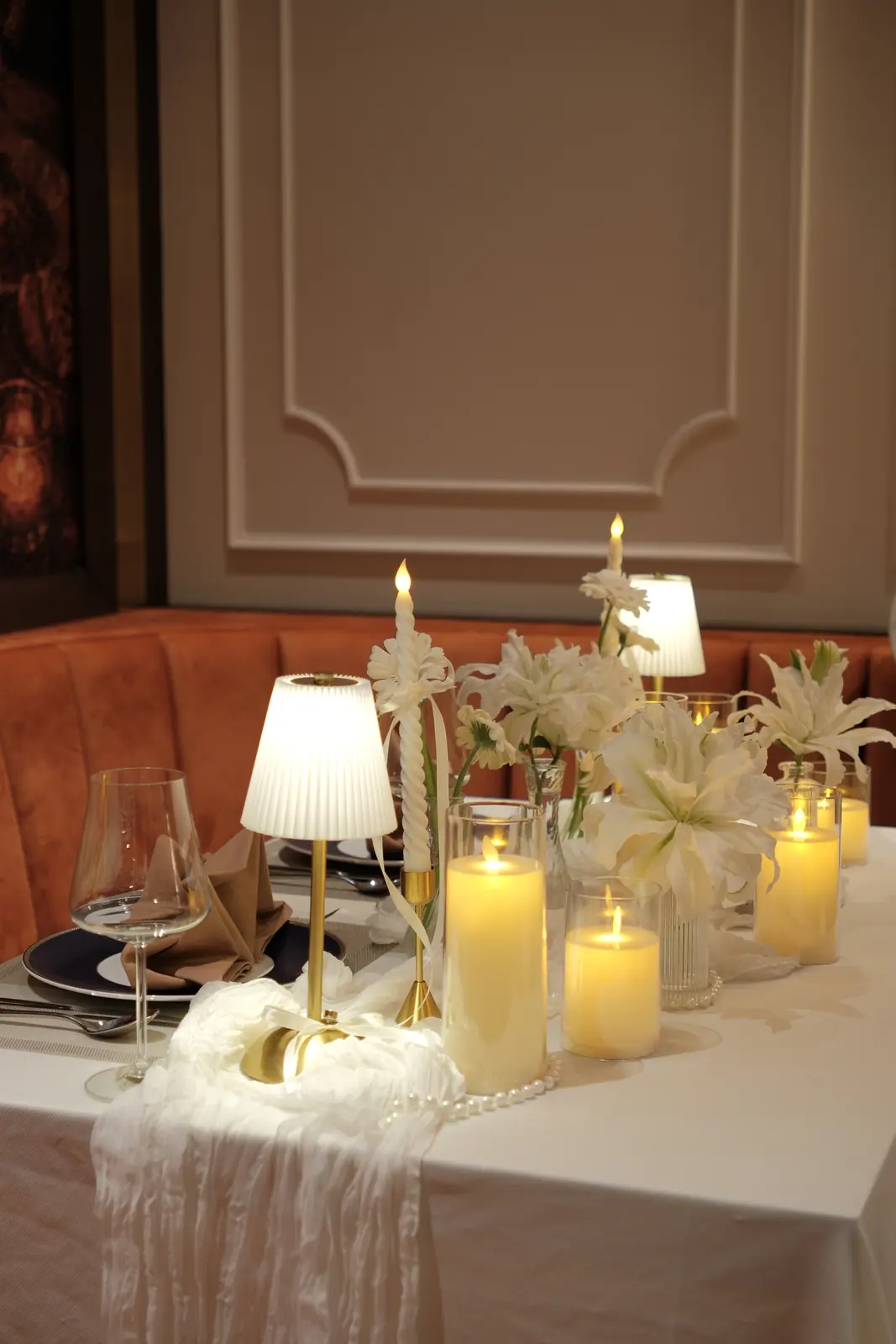 White lilies and pillar candles along a table — Lumé Restaurant · Classyc Hàng Buồm