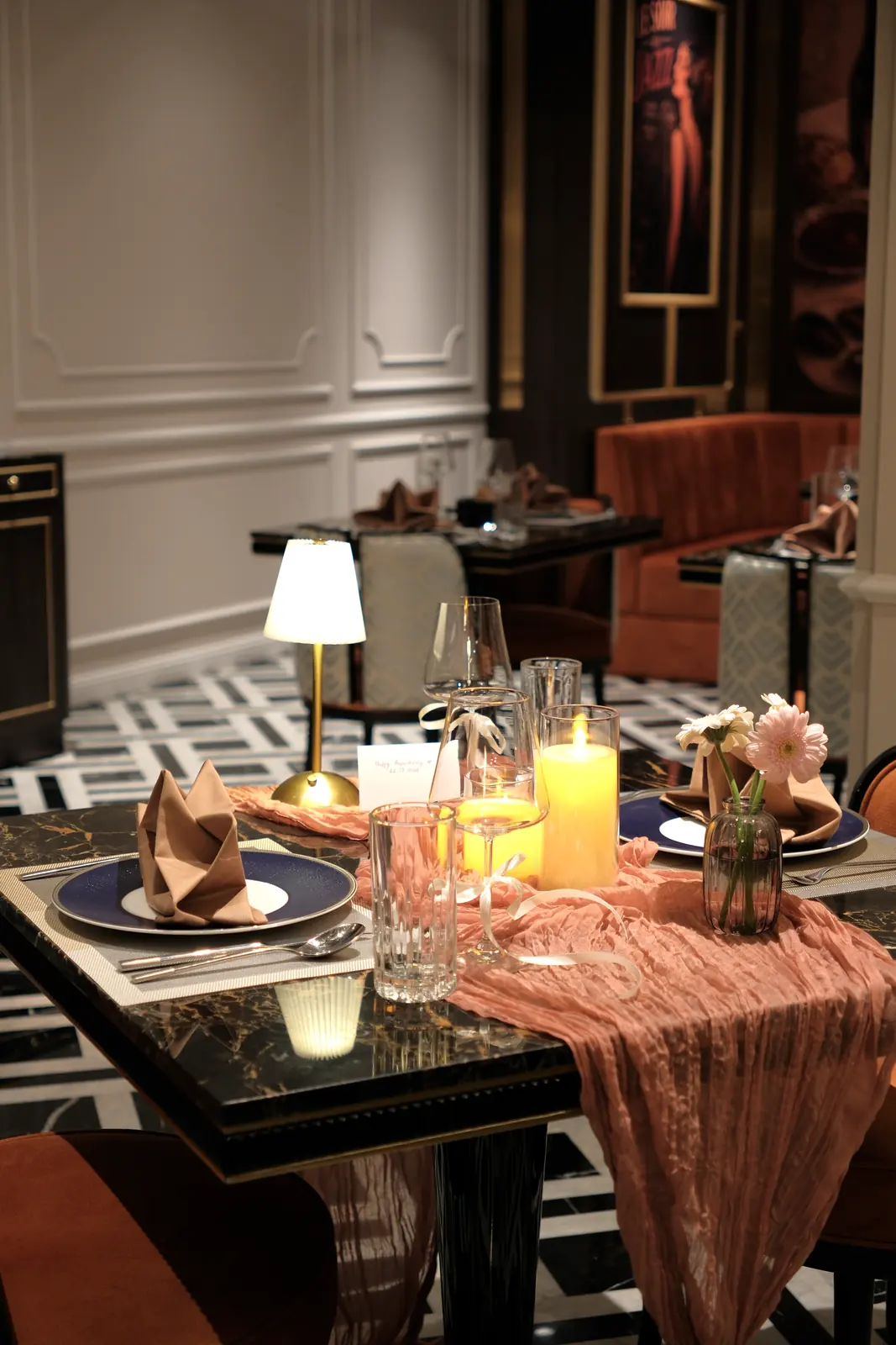 Table with a pink runner, a candle and gerberas — Lumé Restaurant · Classyc Hàng Buồm
