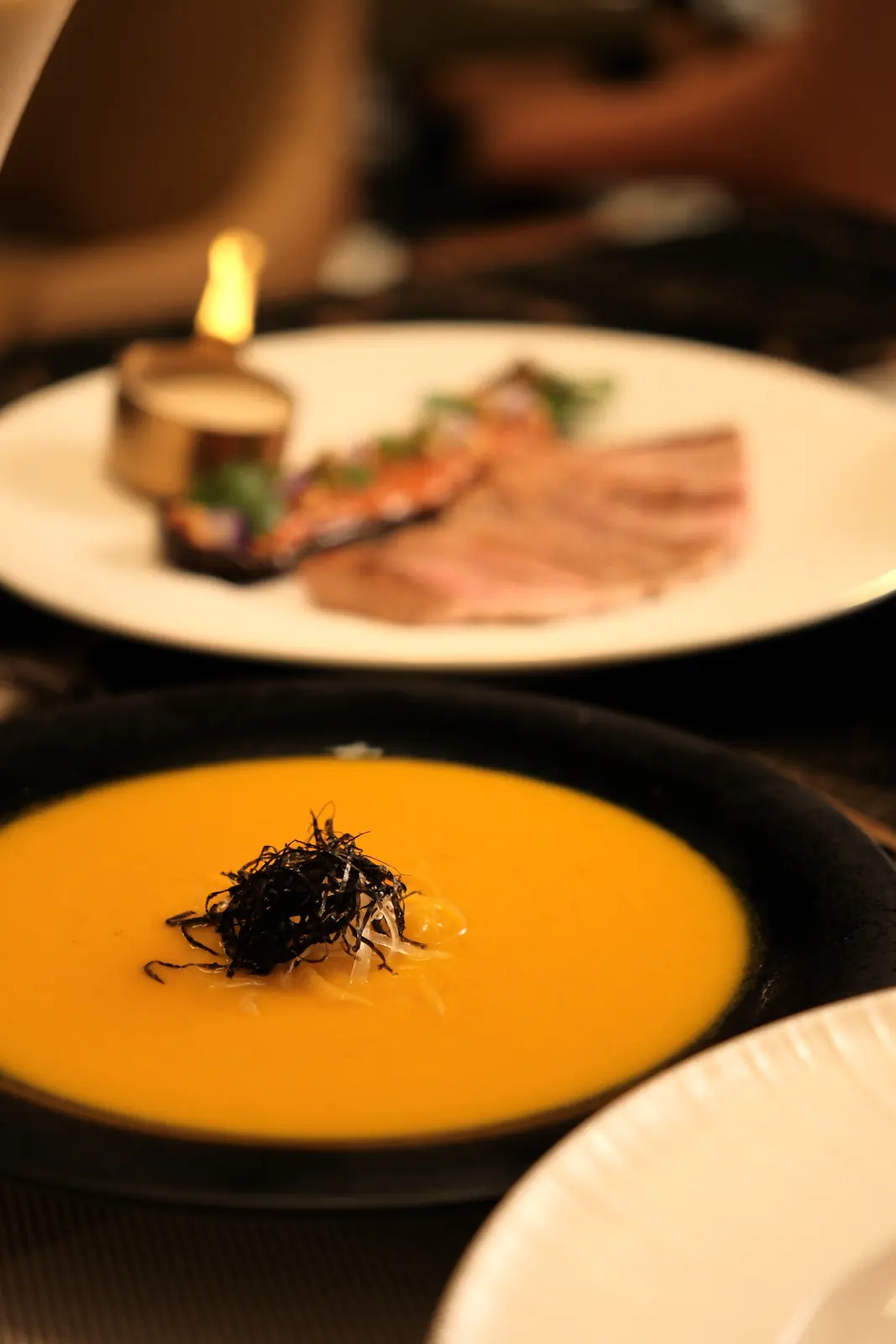 Orange soup with a small flame beside the bowl — Lumé Restaurant · Classyc Hàng Buồm