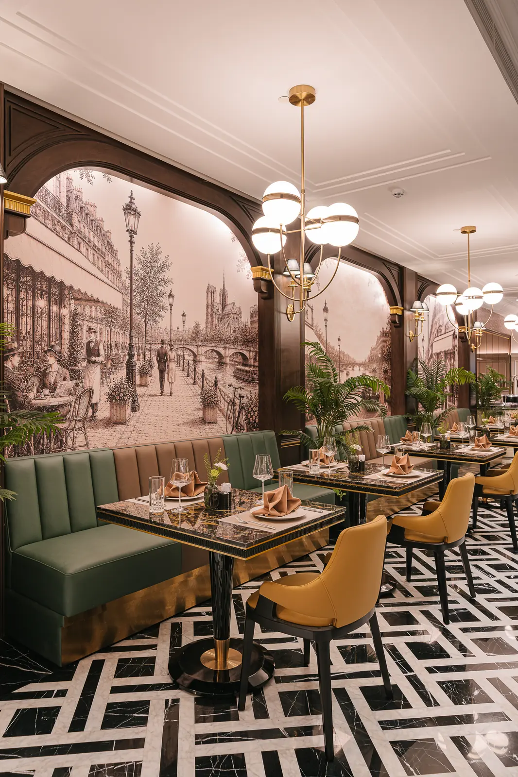 Green booth and a set table in front of a wall mural — Lumé Restaurant · Classyc Hàng Buồm